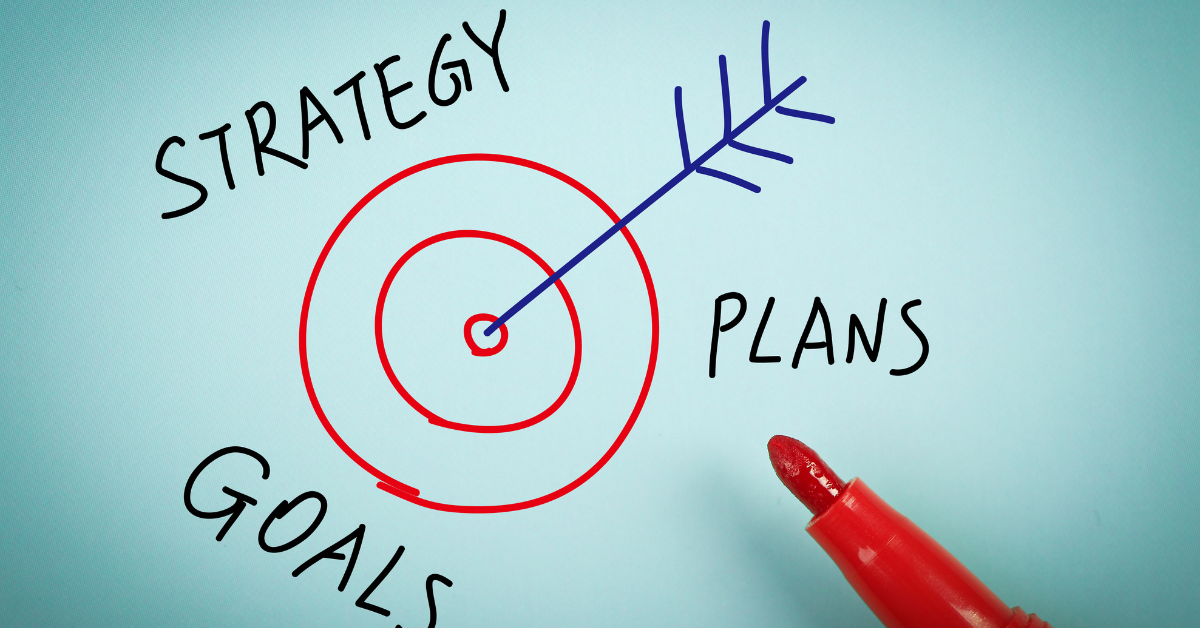 Drawing of a bullseye with an arrow embedded in the center, surrounded by the words "strategy", "goals", and "plans".