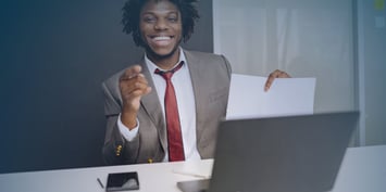 A man in business attire points at a laptop, illustrating the concept of maintaining motivation and control during job hunting.