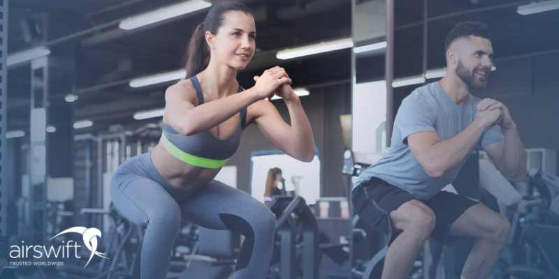 A woman and a man are in the gym, partaking in a workout class