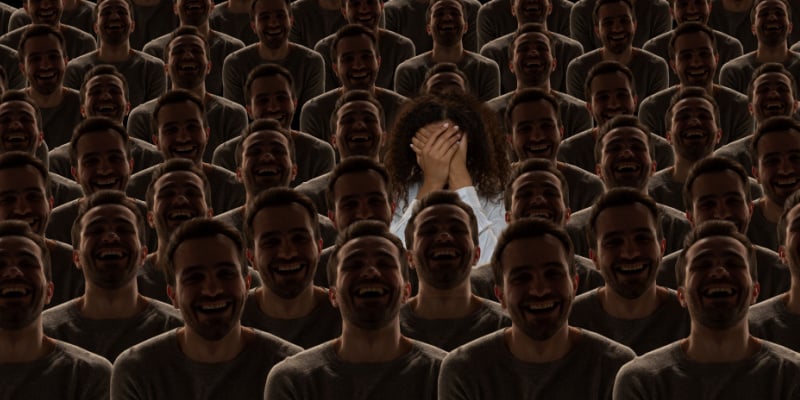 Girl covering her face with her hands while standing in a crowd of identical people