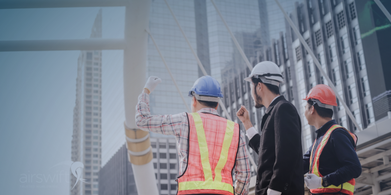 Workers discuss about a building on a construction site 