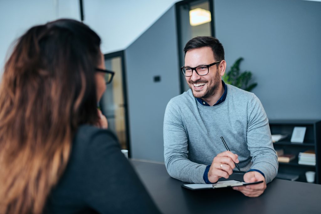 man and woman smiling during a job interview session