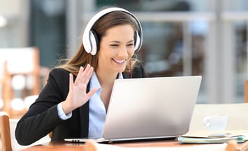 Woman smiling while wearing headphones during a video call