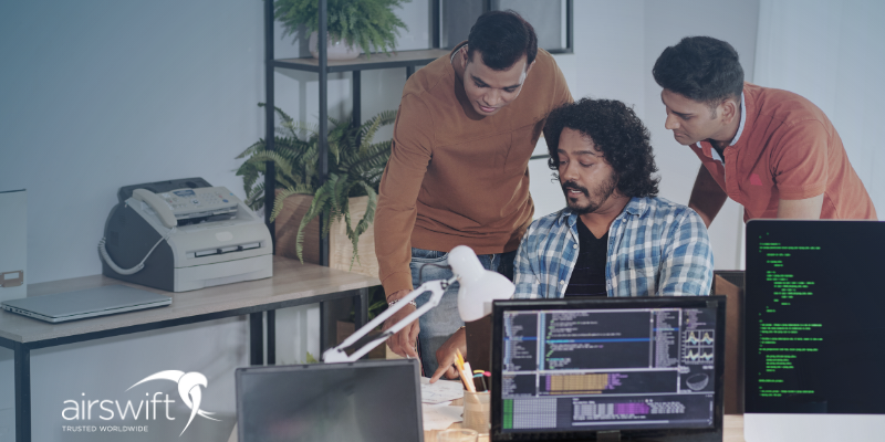 coworkers discussing a project looking at the screen of a laptop