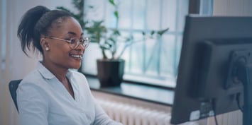 Woman working on a desktop in a bright corporate office