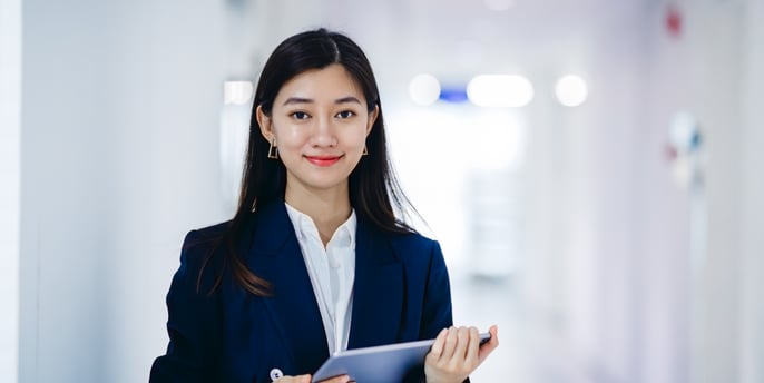 Woman dressed in business attire holding a tablet