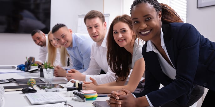 People in smart casual outfits paying attention at a conference table