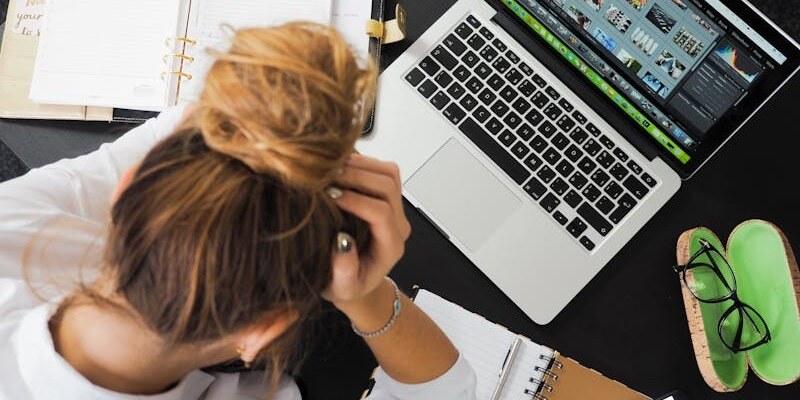 woman at a laptop with her head in her hands