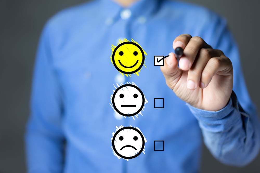 A man in a blue shirt ticks a checkbox beside a happy emoji.