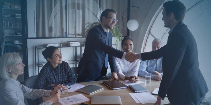 A group of business professionals shaking hands during a meeting, symbolising collaboration and partnership between business entities and EOR