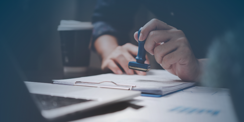 A person stamps a seal on paper, emphasising the importance of accurate documentation for visa applications.