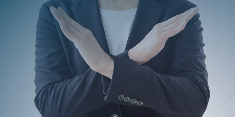 A woman in a business suit makes a hand gesture, illustrating key points about declining job offers in a professional context.