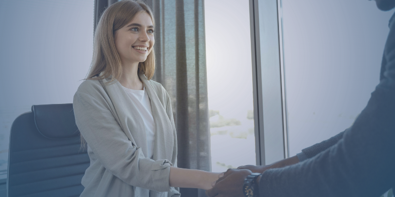 A young woman shakes hands with her boss on her first day at a new job