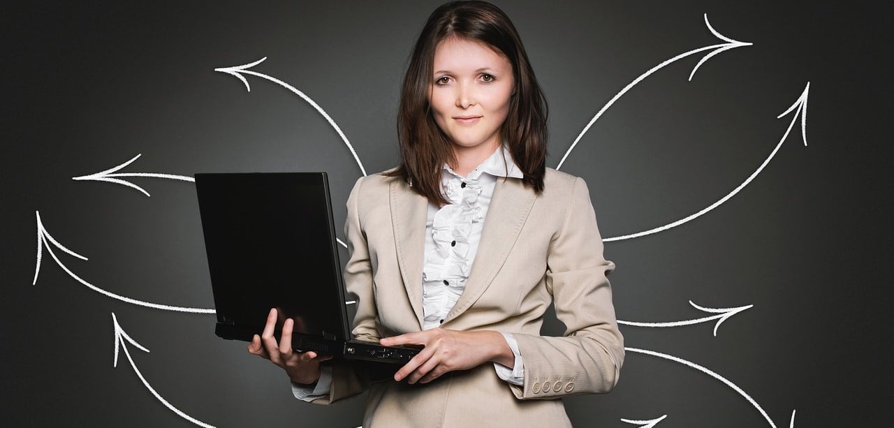 Lady in business attire holding a laptop