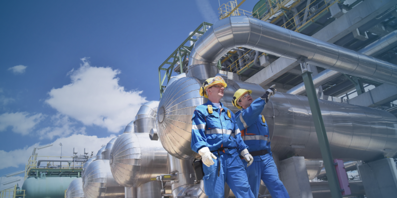 Oil and gas professionals inspecting equipment at an industrial facility