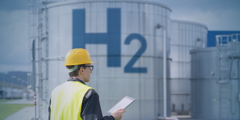 Engineer in safety gear at a green hydrogen facility, illustrating skills gaps holding back green hydrogen projects and the need to close workforce shortages.